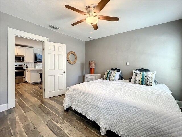 bedroom with visible vents, ceiling fan, and wood finished floors