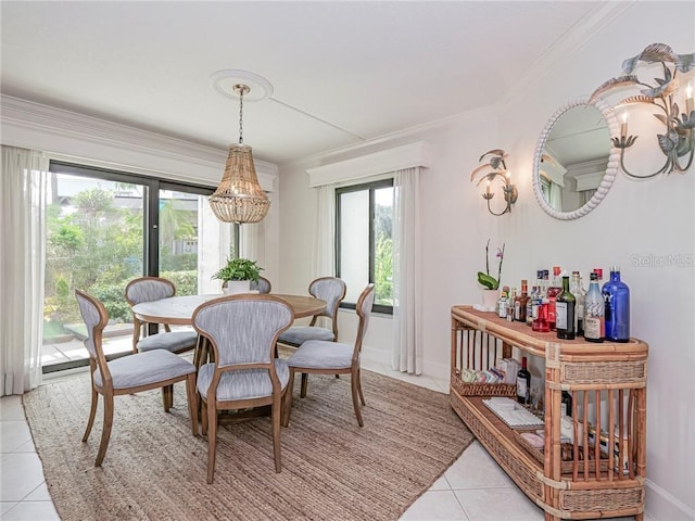 dining space with ornamental molding, plenty of natural light, baseboards, and light tile patterned floors