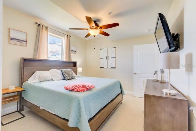 bedroom featuring light colored carpet, ceiling fan, and baseboards