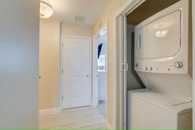 laundry area featuring visible vents, stacked washer and dryer, laundry area, and baseboards