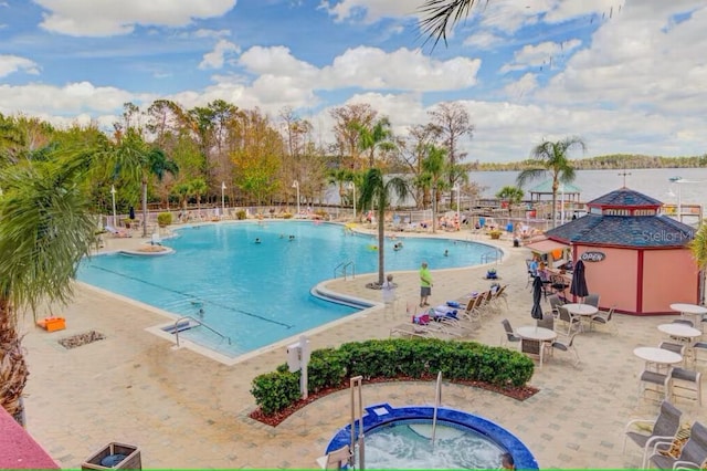 pool featuring a community hot tub, a patio area, and fence