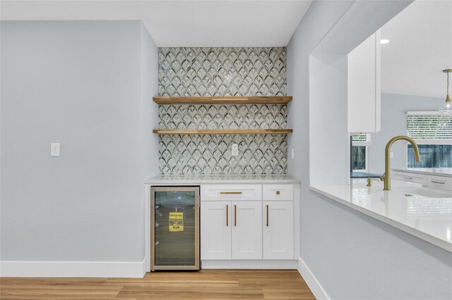 1842 Oklahoma Ave NE, Saint Petersburg, FL 33703 - bar with baseboards, light wood-style flooring, wine cooler, a dry bar, and backsplash