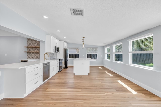 1842 Oklahoma Ave NE, Saint Petersburg, FL 33703 - kitchen with light wood finished floors, visible vents, light countertops, appliances with stainless steel finishes, and white cabinets