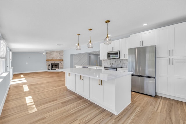 1842 Oklahoma Ave NE, Saint Petersburg, FL 33703 - kitchen featuring a sink, decorative backsplash, light countertops, white cabinets, and stainless steel appliances