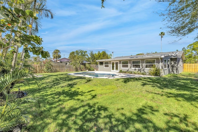 1842 Oklahoma Ave NE, Saint Petersburg, FL 33703 - back of property featuring stucco siding, a lawn, a fenced in pool, and a fenced backyard