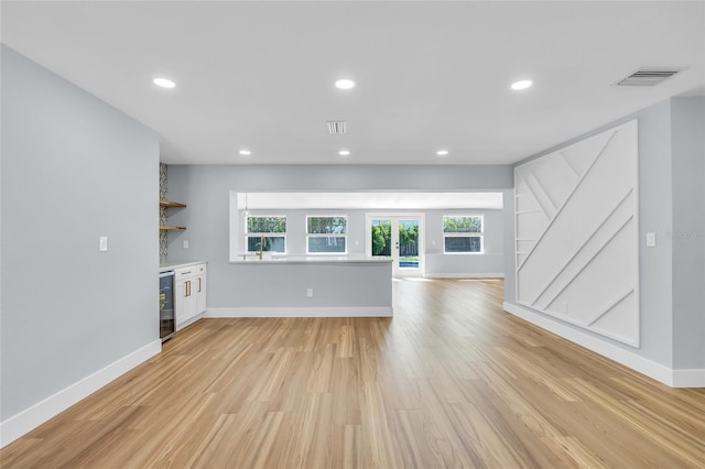 1842 Oklahoma Ave NE, Saint Petersburg, FL 33703 - unfurnished living room featuring beverage cooler, light wood-style floors, and recessed lighting