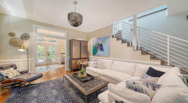 living room with french doors, ornamental molding, wainscoting, wood finished floors, and stairs