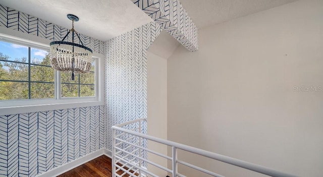 spacious closet featuring a chandelier and dark wood-type flooring