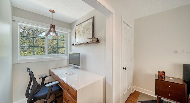 home office with baseboards and wood finished floors