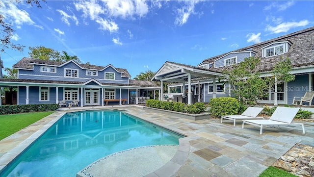 pool with french doors and a patio area