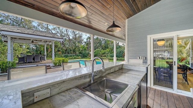 view of patio / terrace featuring an outdoor pool, a sink, and ceiling fan