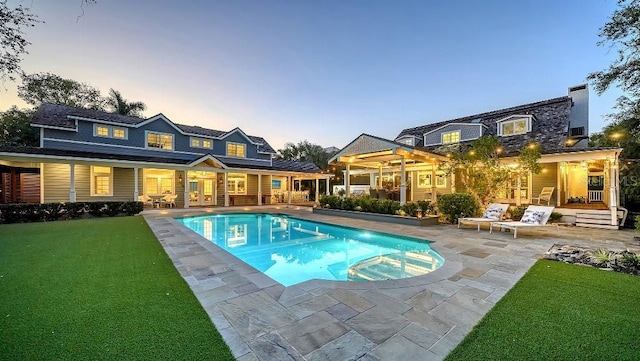 back of house featuring a patio, french doors, a lawn, and an outdoor pool