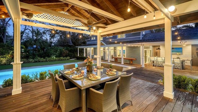 deck featuring ceiling fan, a swimming pool, and outdoor dining area