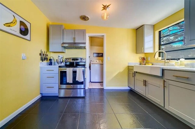 kitchen featuring washer / dryer, stainless steel electric range, a sink, gray cabinetry, and under cabinet range hood