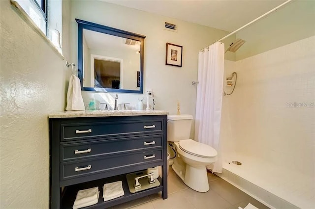 bathroom featuring visible vents, toilet, a stall shower, and vanity