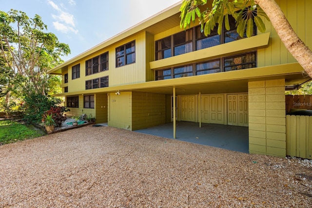 view of property with gravel driveway and a carport