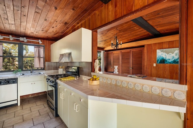 kitchen featuring stainless steel gas range oven, dishwasher, wood ceiling, and a sink