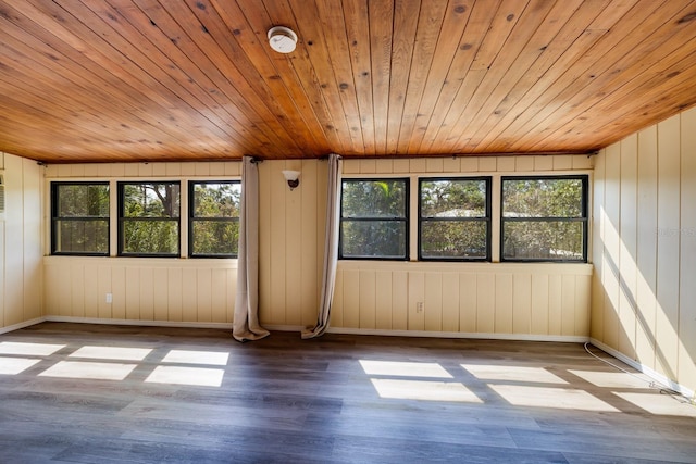 unfurnished room featuring wooden ceiling, baseboards, and wood finished floors