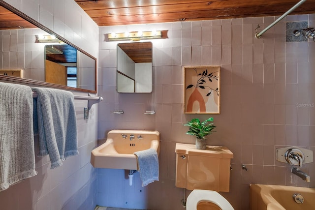 full bathroom featuring toilet, tile walls, shower / tub combination, and a sink