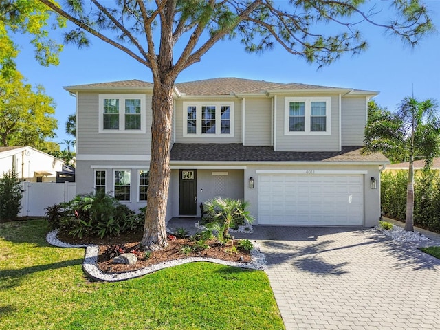 4012 W Morrison Ave, Tampa, FL 33629 - view of front of property featuring a front yard, fence, a shingled roof, a garage, and decorative driveway