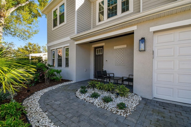 4012 W Morrison Ave, Tampa, FL 33629 - view of exterior entry with stucco siding, a porch, and a garage