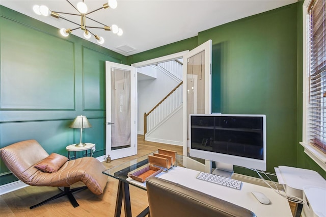 4012 W Morrison Ave, Tampa, FL 33629 - home office with a decorative wall, wood finished floors, visible vents, and a chandelier