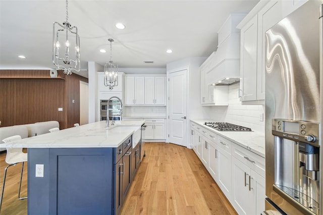 4012 W Morrison Ave, Tampa, FL 33629 - kitchen with light wood-type flooring, a breakfast bar area, white cabinets, and custom range hood