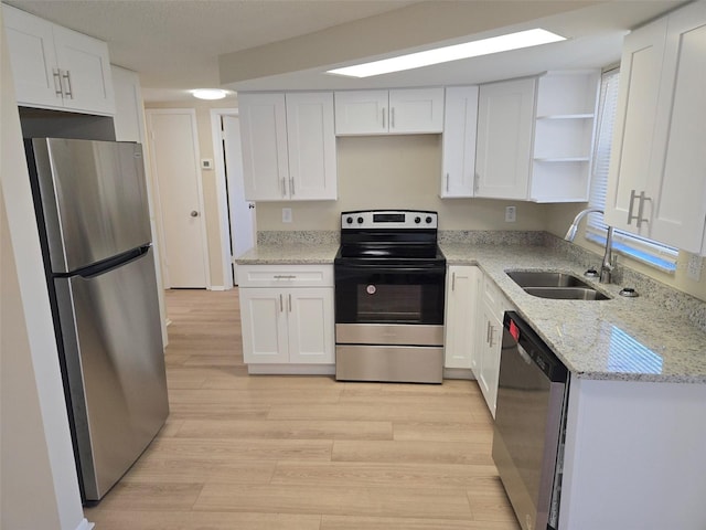 kitchen with stainless steel appliances, a sink, white cabinetry, light wood-style floors, and open shelves