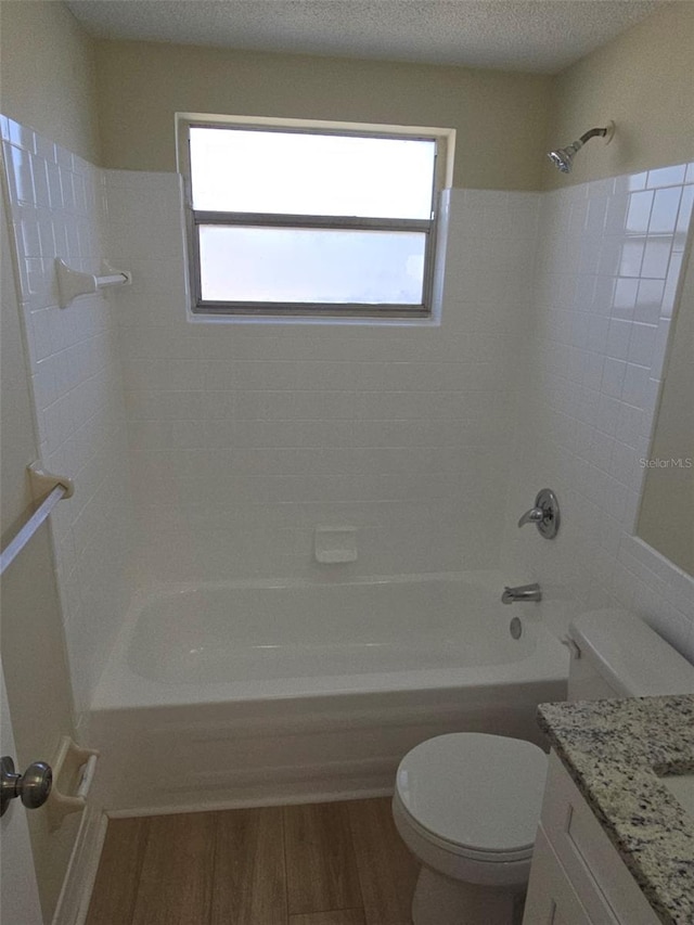 bathroom with a wealth of natural light, shower / bath combination, wood finished floors, and toilet