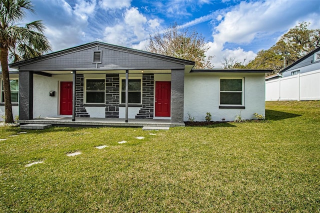 view of front of property featuring a front yard, fence, and stucco siding