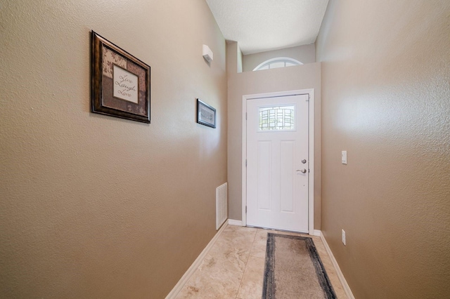 entryway featuring visible vents, baseboards, and a textured wall