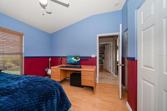 bedroom featuring light wood-type flooring, lofted ceiling, and a ceiling fan