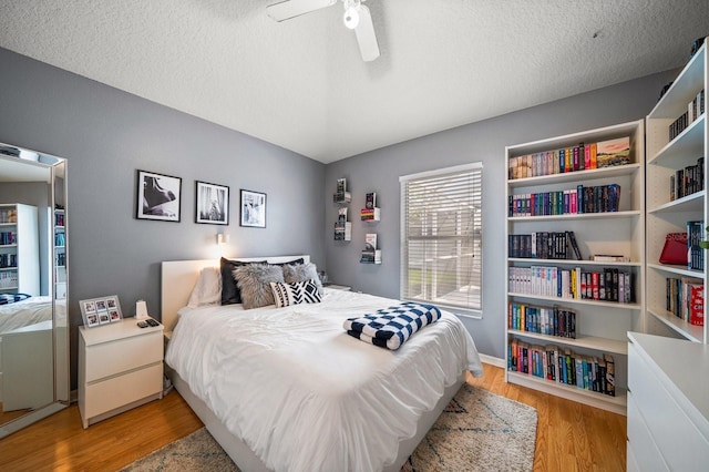 bedroom featuring light wood-style floors, a ceiling fan, and a textured ceiling