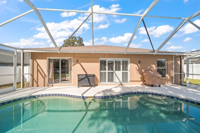 back of house with a lanai, a patio, and stucco siding