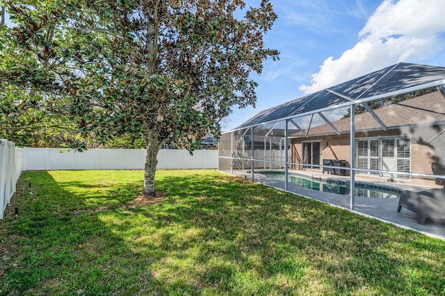 view of yard with glass enclosure, a patio area, a fenced backyard, and a fenced in pool