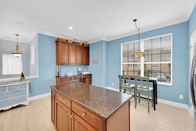 kitchen with ornamental molding, a center island, and baseboards