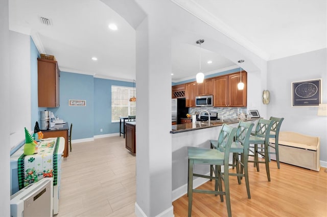 kitchen with crown molding, appliances with stainless steel finishes, visible vents, and brown cabinets