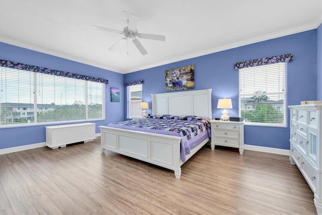 bedroom with a ceiling fan, crown molding, light wood-style flooring, and baseboards