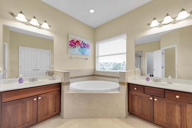 full bath featuring tile patterned flooring, two vanities, a sink, and a bath