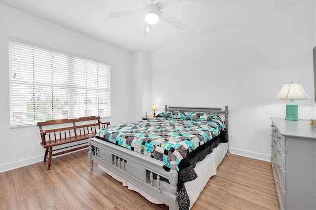 bedroom featuring light wood-type flooring, baseboards, and a ceiling fan