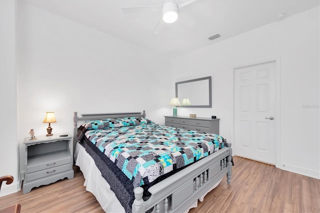 bedroom featuring light wood-type flooring, baseboards, visible vents, and a ceiling fan