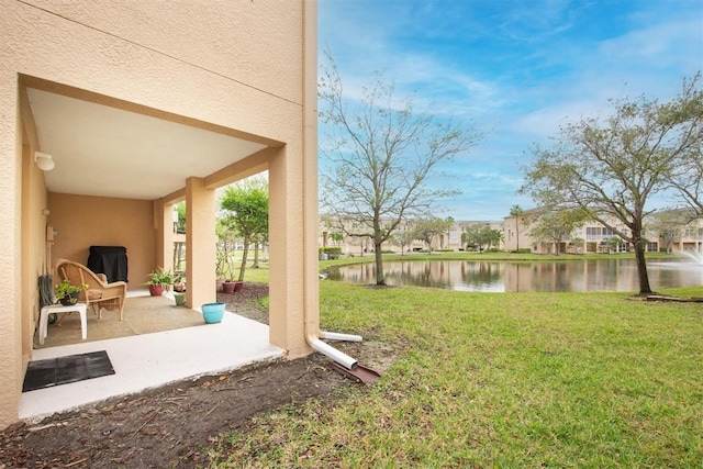 view of yard with a patio area and a water view