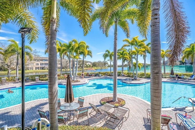 community pool with fence and a patio