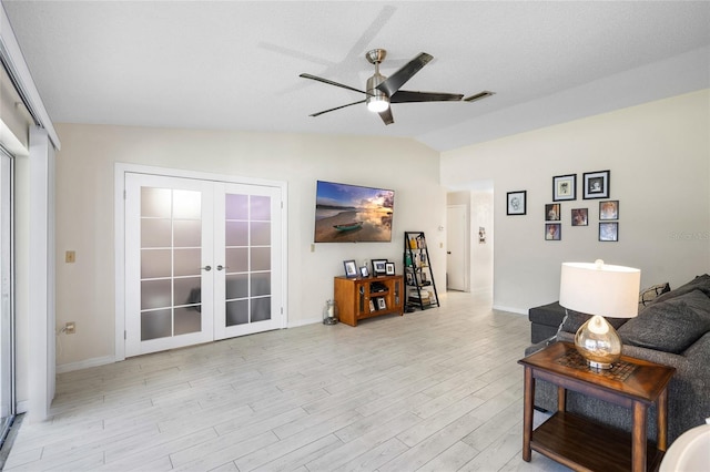 living room with a ceiling fan, visible vents, vaulted ceiling, french doors, and light wood-type flooring