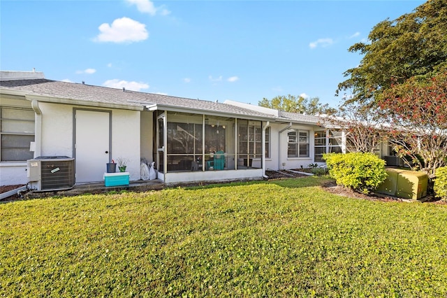 back of property with stucco siding, cooling unit, a yard, and a sunroom