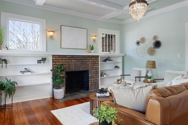 living area with coffered ceiling, beam ceiling, a fireplace, ornamental molding, and wood-type flooring