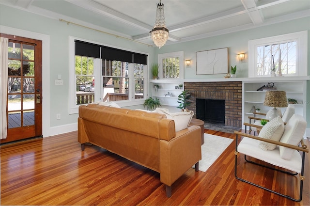 living area featuring plenty of natural light, coffered ceiling, wood finished floors, and a fireplace