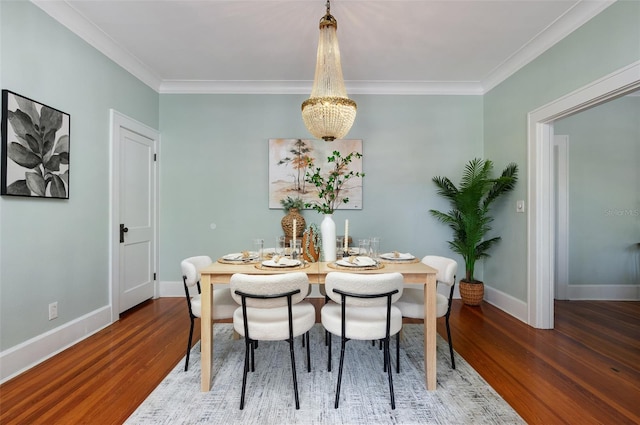 dining space with crown molding, a notable chandelier, wood finished floors, and baseboards