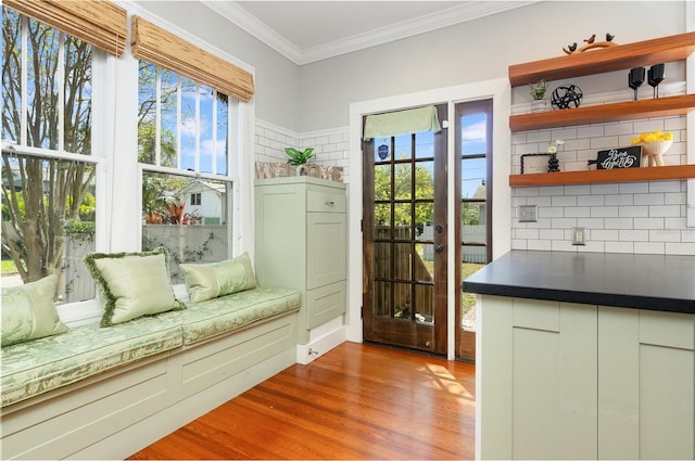 interior space featuring plenty of natural light, crown molding, and wood finished floors