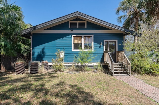 bungalow-style home featuring a front yard and central air condition unit